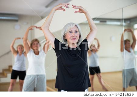 Mature active women perform ballet exercises in the studio 94212629