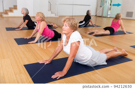 Group of elderly women performs an exercise in the dog pose face up 94212630