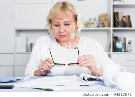 Woman engaged in home accounting 94212671