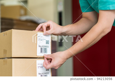 Man applying labels by hand before shipping 94213056