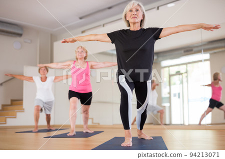 Mature women exercising yoga pose Mature women exercising yoga pose 94213071