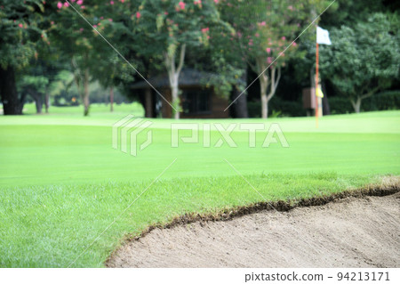 Golf course green and white flag 94213171
