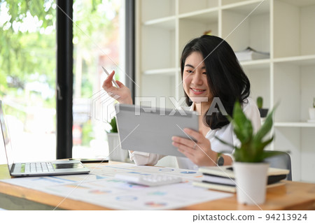 Asian businesswoman planning her financial investment strategy on a digital tablet. Asian businesswoman planning her financial investment strategy on a digital tablet. 94213924