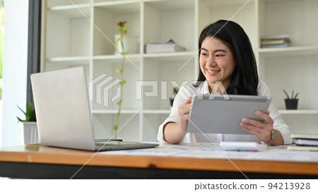 Successful Asian businesswoman using digital tablet and laptop computer Successful Asian businesswoman using digital tablet and laptop computer 94213928