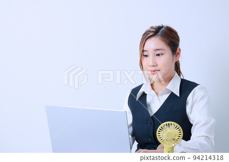 一個冷靜下來和一個方便的風扇一起工作的女人 一個冷靜下來和一個方便的風扇一起工作的女人 94214318