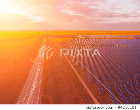 Aerial top view of a solar panels power plant. Photovoltaic solar panels at sunrise and sunset in countryside from above. Modern technology, climate care, earth saving, renewable energy concept. Aerial top view of a solar panels power plant. Photovoltaic solar panels at sunrise and sunset in countryside from above. Modern technology, climate care, earth saving, renewable energy concept. 94216191
