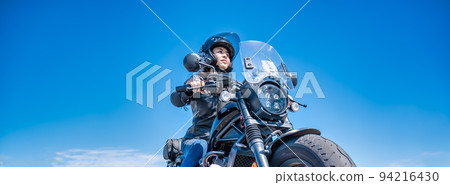 A female rider touring Yokohama on a large cruiser bike A female rider touring Yokohama on a large cruiser bike 94216430