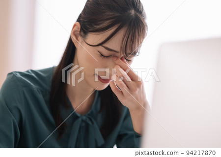 Image of a woman whose eyes are tired from desk work and personal computer 94217870