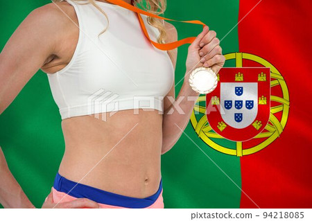 Midsection of sportswoman with medal against Portuguese Flag 94218085