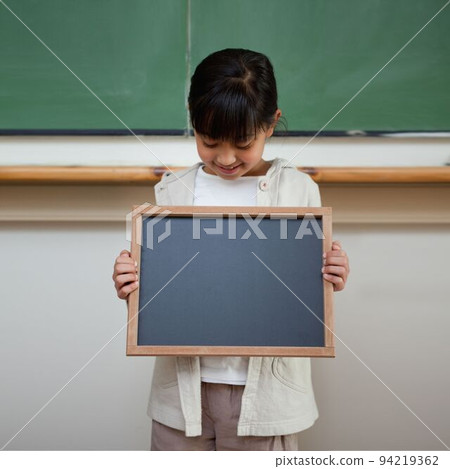 Cute pupil showing chalkboard 94219362