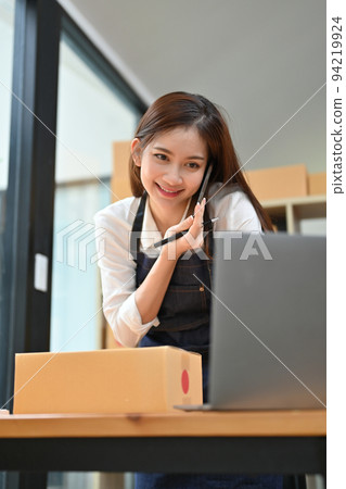 Portrait, Beautiful young Asian female business startup talking on the phone with her supplier. 94219924