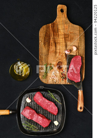 Overhead view of raw boneless beef strip steak ready for frying Overhead view of raw boneless beef strip steak ready for frying 94220125
