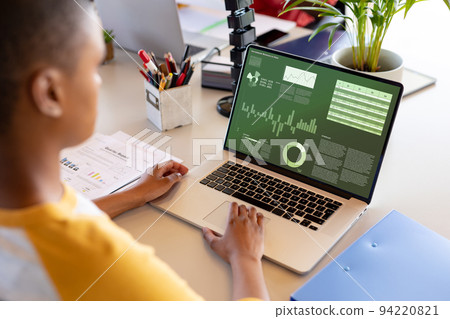 African american businesswoman using laptop with data processing 94220821
