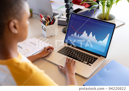 African american businesswoman using laptop with data processing African american businesswoman using laptop with data processing 94220822