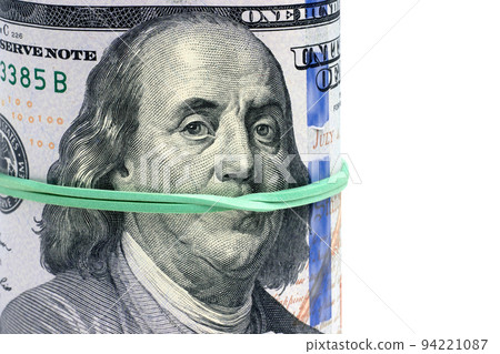 Rolled hundred dollar bills are tied with a green banker's rubber band. Portrait of Franklin gagged. Pay for silence, corruption Rolled hundred dollar bills are tied with a green banker's rubber band. Portrait of Franklin gagged. Pay for silence, corruption 94221087