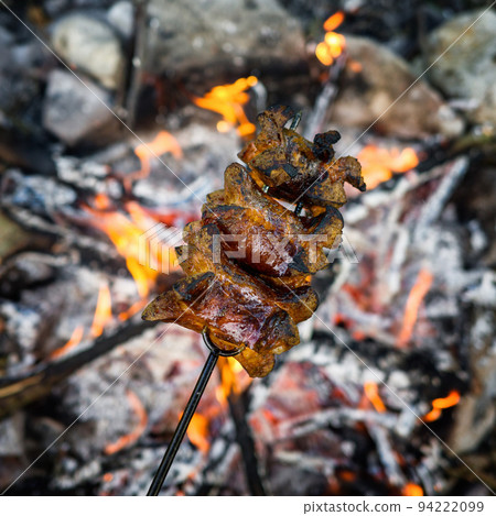 Flames grilling a steak on the bbq bonfire, campfire summer 94222099