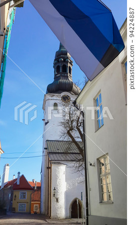 National Flag of Estonia and Medieval Toomkirik - Dome Church St. Mary`s Cathedral on Toompea Hill in Tallinn Old Town, Talli. Estonian Historic clock tower. 94224887