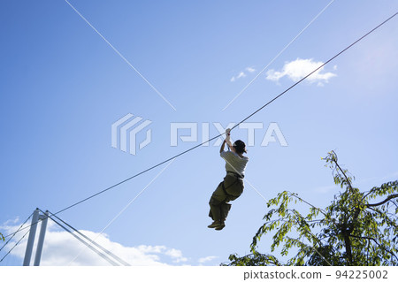 Woman sliding down a zipline 94225002