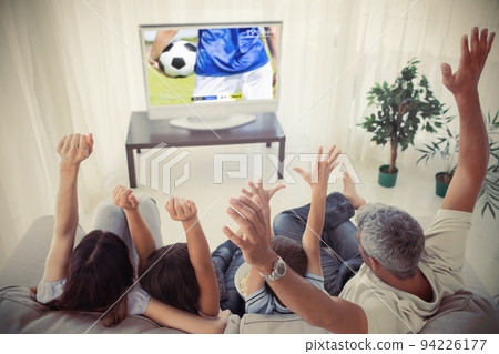 Happy caucasian american family watching football match together and sitting on the couch 94226177