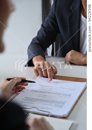 Cropped shot of male lawyer providing law consultation and legal advice to client and showing place for signature on contract document Cropped shot of male lawyer providing law consultation and legal advice to client and showing place for signature on contract document 94226506