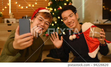 Happy friends using smartphone and take selfie in room decorated for celebrating New year and Christmas festive 94226620