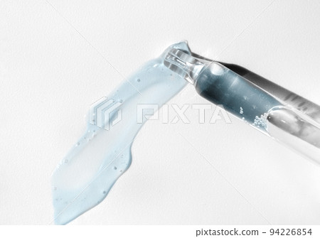 Pipette with fluid serum, oil, face gel cleaner. Cosmetics and healthcare concept closeup. Dose of retinol with air bubbles. Flat lay. Monkeypox, coronavirus research 94226854