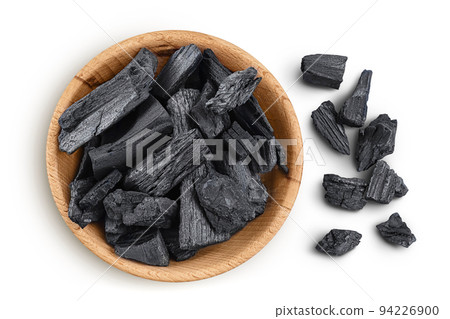Natural charcoal in wooden bowl isolated on white background with full depth of field. Top view. Flat lay Natural charcoal in wooden bowl isolated on white background with full depth of field. Top view. Flat lay 94226900