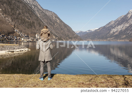 Father and son enjoying mountains, snow, lake, good weather, blue sky, sun. Little boy and his father spending time together. Family time. Beautiful landscape. Tourism, holiday, travel. Amazing view. Father and son enjoying mountains, snow, lake, good weather, blue sky, sun. Little boy and his father spending time together. Family time. Beautiful landscape. Tourism, holiday, travel. Amazing view. 94227055