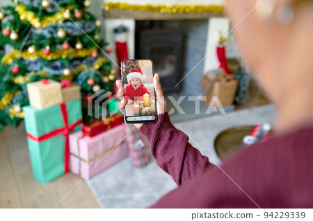Woman making smartphone christmas video call with excited caucasian boy in santa hat Woman making smartphone christmas video call with excited caucasian boy in santa hat 94229339