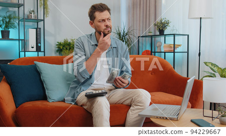 Rich happy man counting money cash and use calculator, calculate domestic income earnings at home 94229667