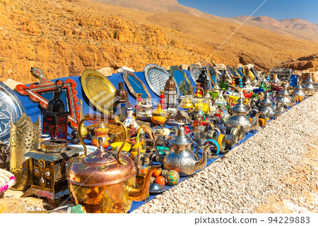 Multicolored Moroccan craft souvenirs at the market. Teapots and plates , decorations, tagines,, trinkets Multicolored Moroccan craft souvenirs at the market. Teapots and plates , decorations, tagines,, trinkets 94229883
