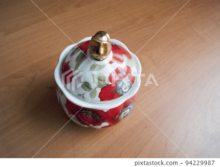 Porcelain sugar bowl is on the tabl 94229987