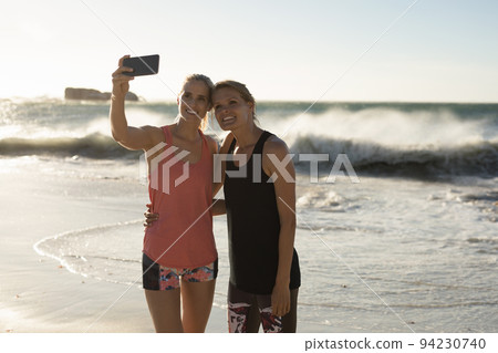 Women taking selfie on the beach Women taking selfie on the beach 94230740
