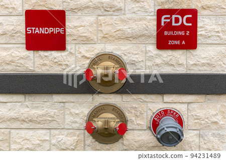 Manual standpipes, automatic sprinkler fire department connection, red signs with inscriptions on the wall of building 94231489