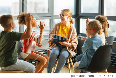 schoolchildren raise their hand looking at teacher to answer in class during psychological training schoolchildren raise their hand looking at teacher to answer in class during psychological training 94232373
