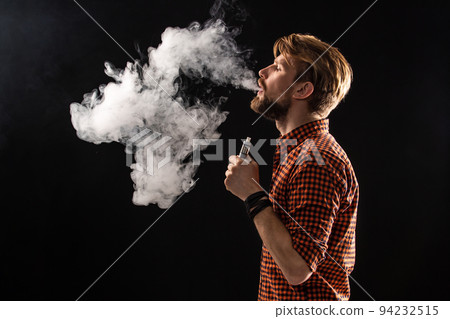 A young man with a beard and a stylish hairstyle in a shirt, smoking a cigarette, a viper, a room, a studio, smoke, enjoyment 94232515