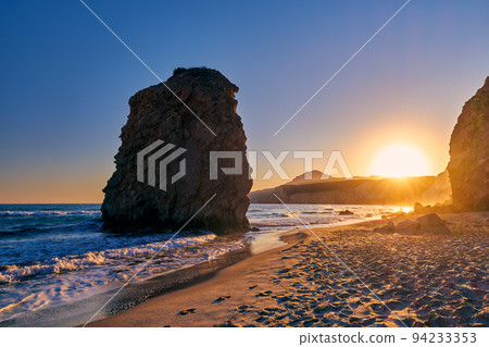 Colorful sunset on Fyriplaka beach, Milos, Greece. No people, low sun. Iconic Fyriplaka lonely rock against low sun, colorful sky and sea 94233353