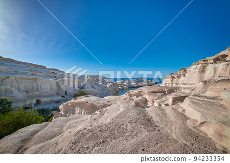 Famous white rocks of Sarakiniko beach, Aegean sea, Milos island , Greece. No people, empty cliffs, summer sunshine, blue sky and clouds 94233354