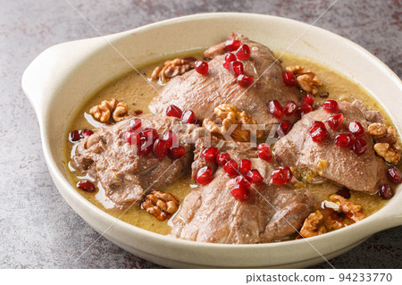 Delicious chicken stew in pomegranate walnut sauce close-up in a plate. Horizontal 94233770