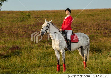 The horsewoman on a red horse. Horse riding. Horse racing. Rider on a horse. 94234128