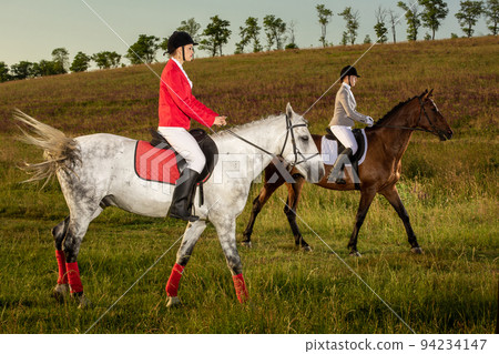 Two young women riding horse in park. Horse walk in summer 94234147
