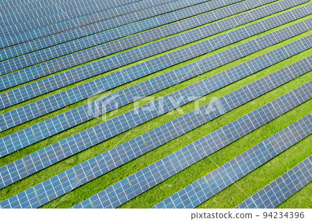 Aerial view of a solar panel for green energy production in a field. Cheap electricity or increasing of price on electricity resources concept Aerial view of a solar panel for green energy production in a field. Cheap electricity or increasing of price on electricity resources concept 94234396