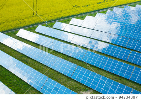 Long rows of sun panels built on green field. Innovative photovoltaic solar cells provide alternative energy at station aerial view 94234397