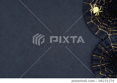 Halloween background. The scary Halloween paper fans with gold cobwebs on a dark textured background. Halloween background. The scary Halloween paper fans with gold cobwebs on a dark textured background. 94235274
