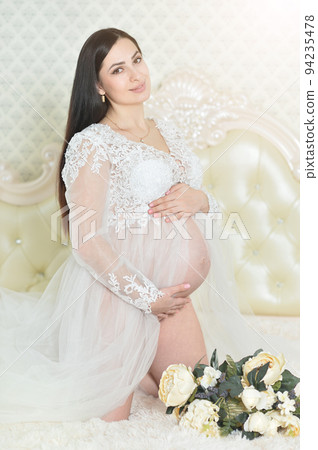 Beautiful pregnant woman posing on sofa at home 94235478