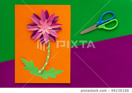 Paper flower craft by child and scissors flat lay 94236188