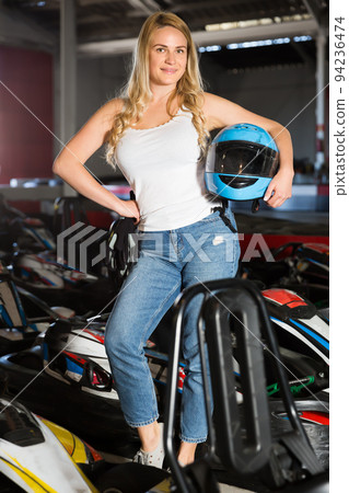 Glad woman with helmet standing near cars Glad woman with helmet standing near cars 94236474