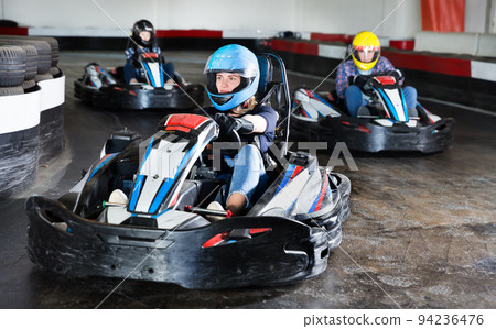 Female racer in helmet driving kart on track Female racer in helmet driving kart on track 94236476
