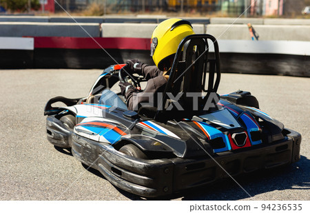 Woman driving sport car for karting in a circuit lap outdoor in sport club Woman driving sport car for karting in a circuit lap outdoor in sport club 94236535