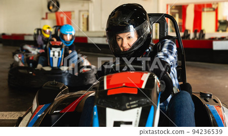 woman driving racing car at kart circuit 94236539